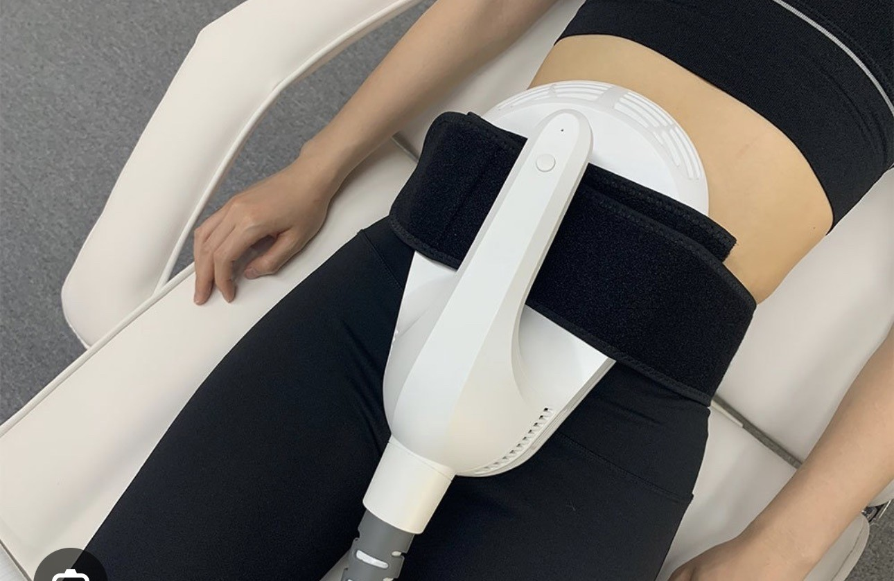 EmSlim applicator strapped over a client's abdomen during a body contouring session